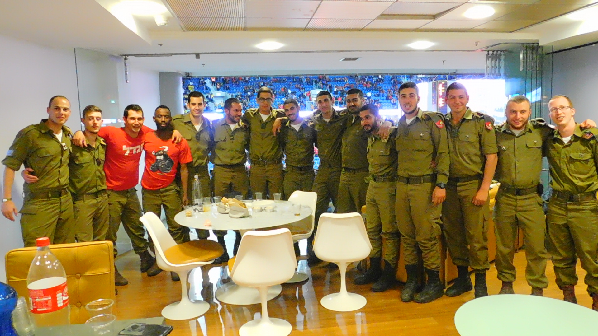 A group of IDF soldiers pose in the VIP box at a sport stadium.
