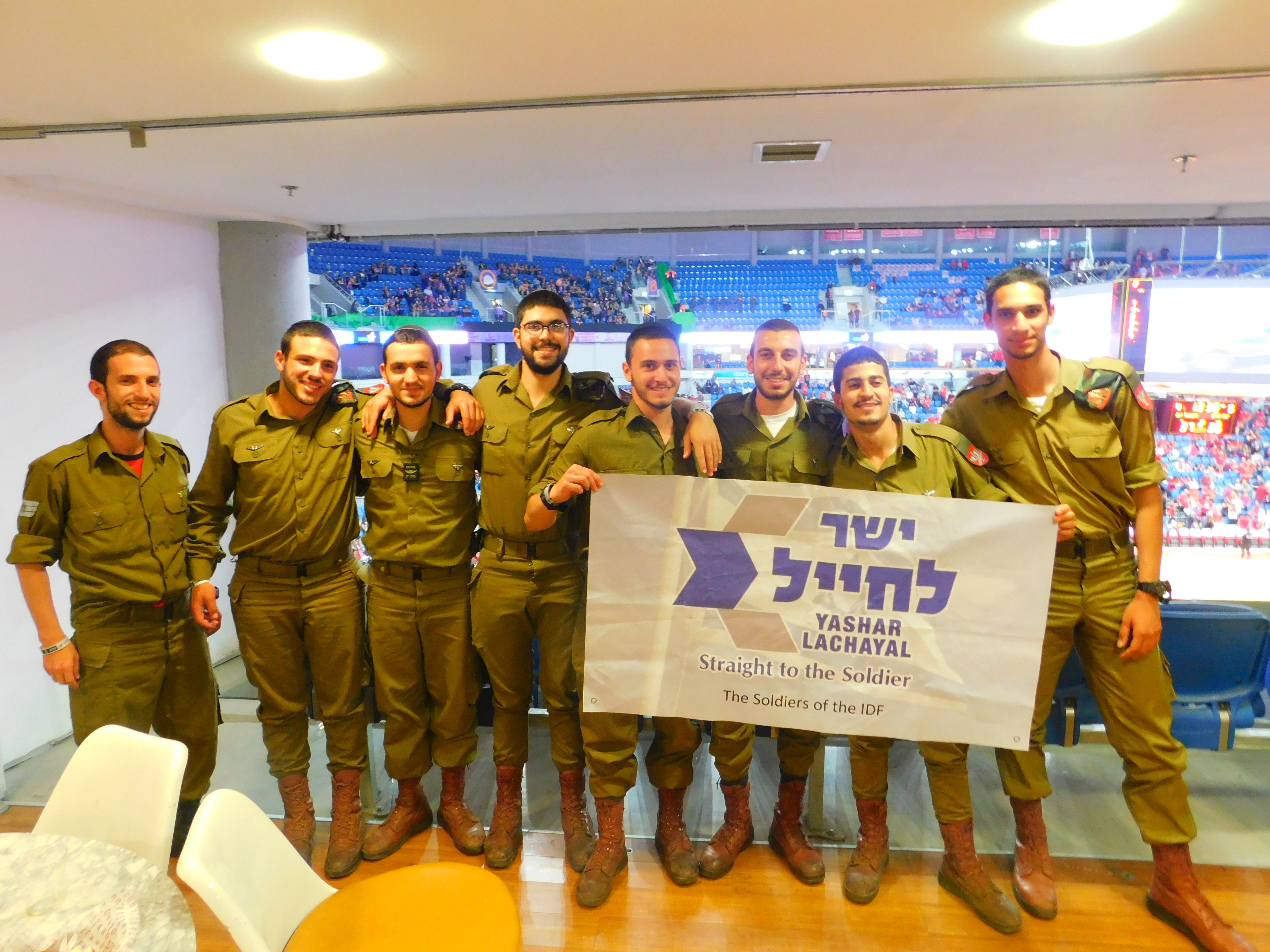 A group of IDF soldiers pose in the VIP box at a sport stadium.